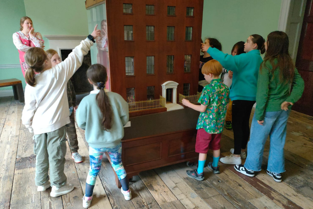 Children look at the model of a house on Henrietta Street on a tour of the museum