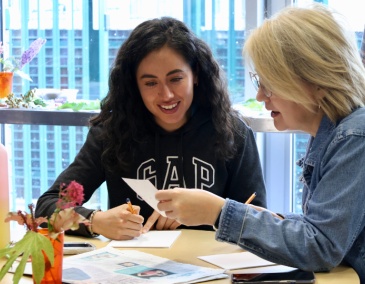 Creative Residencies two people at a table are looking at a drawing 800x540