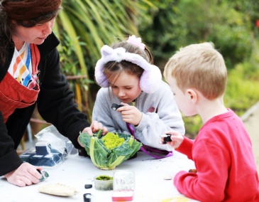 Culture Connects Polly with Rylie and Oisín using a magnifier in the Richmond Barracks garden 800 x 540