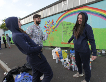 Jorge and students working on the mural