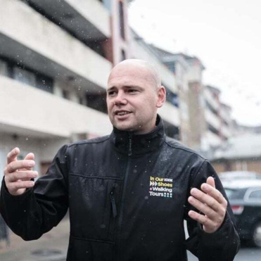 Anthony standing in front of flats