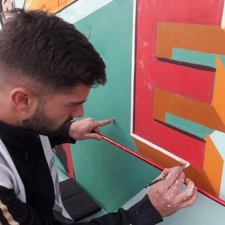 Jorge painting a mural