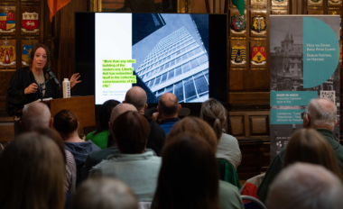 Decorative dublin festival of history 2025 an author shows an image of dublins liberty hall to an audience in the mansion house oak room website 800x540