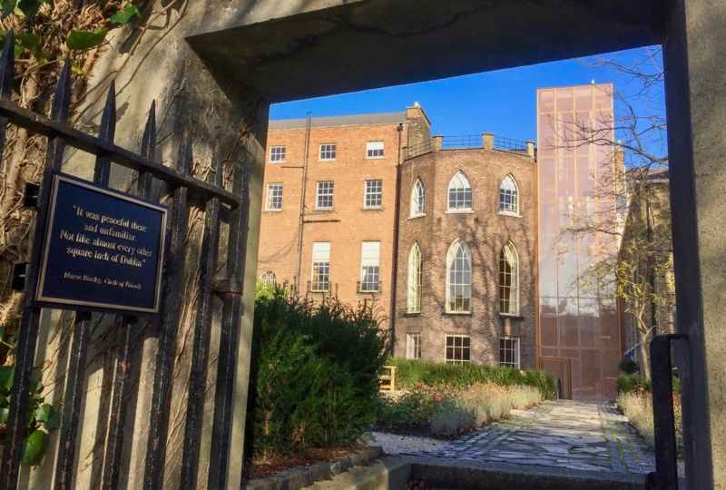 Back of Musem of Literature Ireland seen through a park gate entry point.