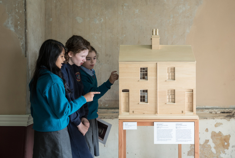 Schoolchildren are exploring a house model in 14 Henrietta Street