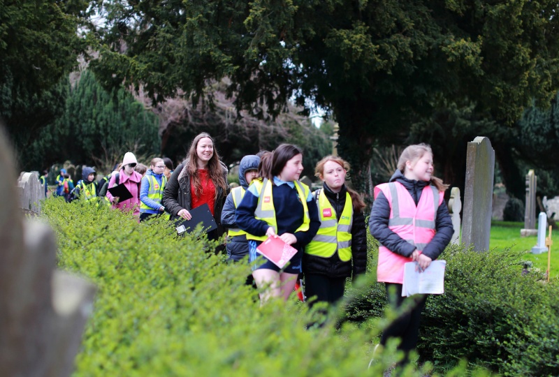 Decorative Schoolchildren wearing high vis vests walk in Goldenbridge Cemetery guided by Historian in Residence for Children Dervila Roche 800x540
