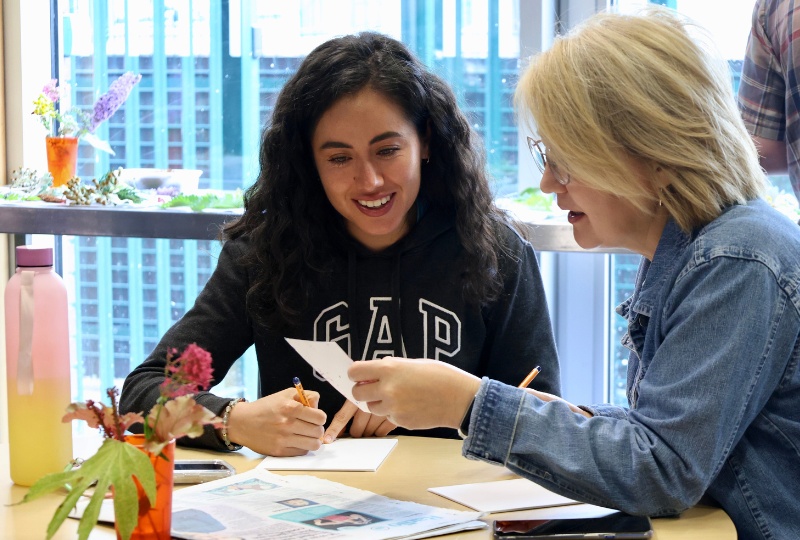 Creative Residencies two people at a table are looking at a drawing 800x540