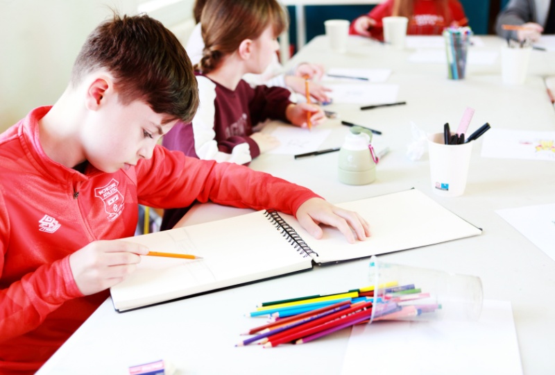 Culture Connects Liam draws on a sketchpad during an artistic workshop in Richmond Barracks 800 x 540