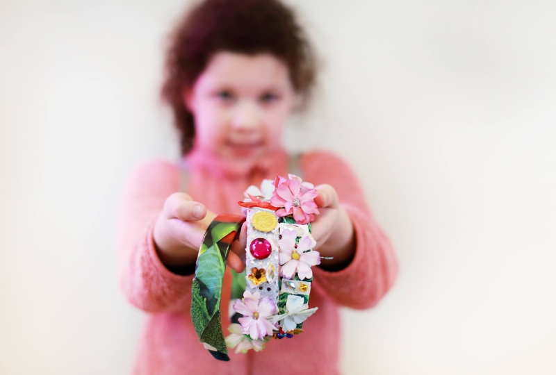 Culture Connects A girl holds bracelets made at a fair in Richmond Barracks up to the camera 800 x 540