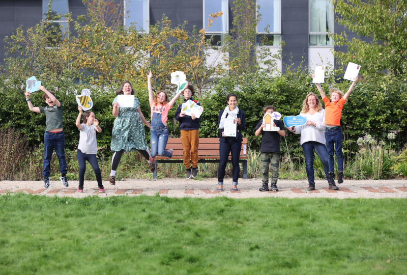 A group of children and a few adults jumping with the biodivesity worksheets
