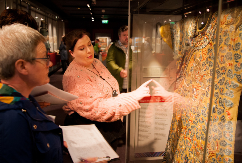 Two women looking at a garment on display in Chester Beatty