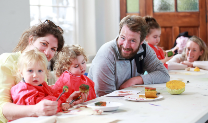 A family of two adults and two children attend a Culture Connects workshop at Richmond Barracks