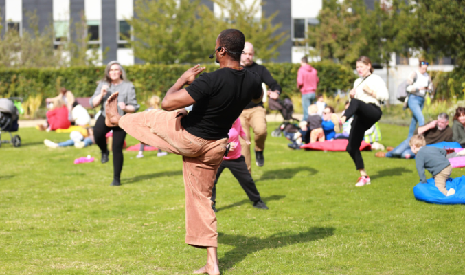 People dance outside at a Culture Connects workshop in the Richmond Barracks garden